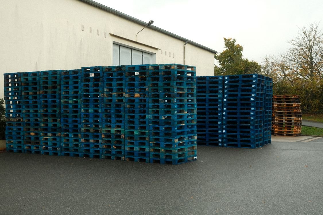 Stacks of pallets at a warehouse — how much does a pallet weigh depends on design and material