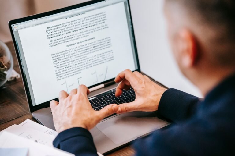 Technical writer preparing software documentation on a laptop