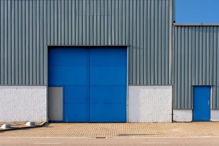 Warehouse for Sale: The Complete Guide to Finding & Buying the Right One warehouse for sale - blue metal warehouse exterior with a large loading door